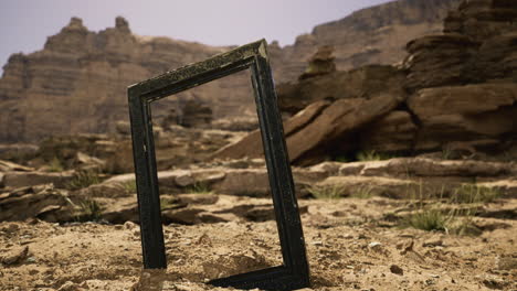 unique frame standing in a dry landscape with rocky mountains in the background