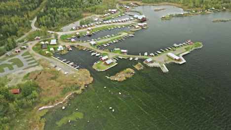 Vista-Aérea-Panorámica-De-Los-Barcos-De-Amarre-En-La-Bahía-Del-Puerto-Deportivo-Con-Casas-Rojas-Durante-El-Otoño-En-Finlandia