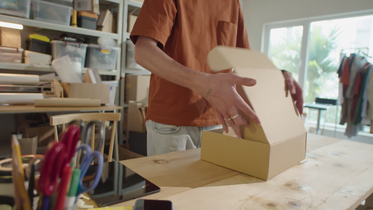 Man Packing Order into Parcel Box in Delivery Service Office