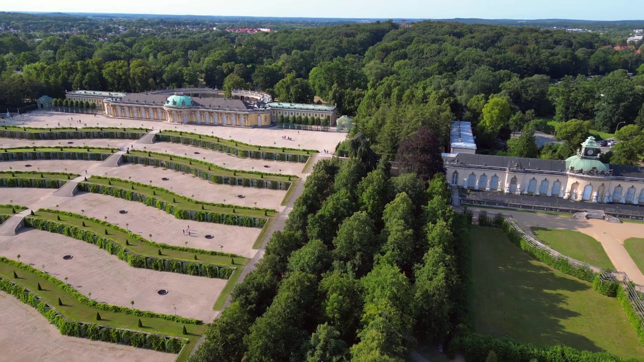 Giornata estiva soleggiata al Palazzo Sanssouci di Potsdam che mostra i bellissimi giardini verdi e l'area circostante. Mozzafiato vista aerea con rotazione del drone verso destra