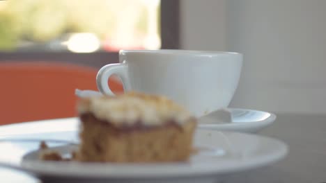 Diner-in-cafe-dunking-biscuit-in-cup-of-coffee