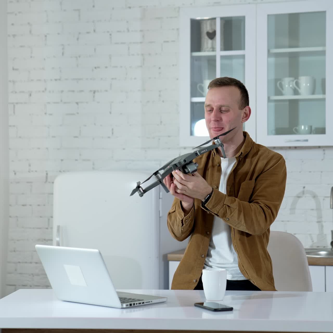 Man with drone at home. Young man man holding drone in hand at home