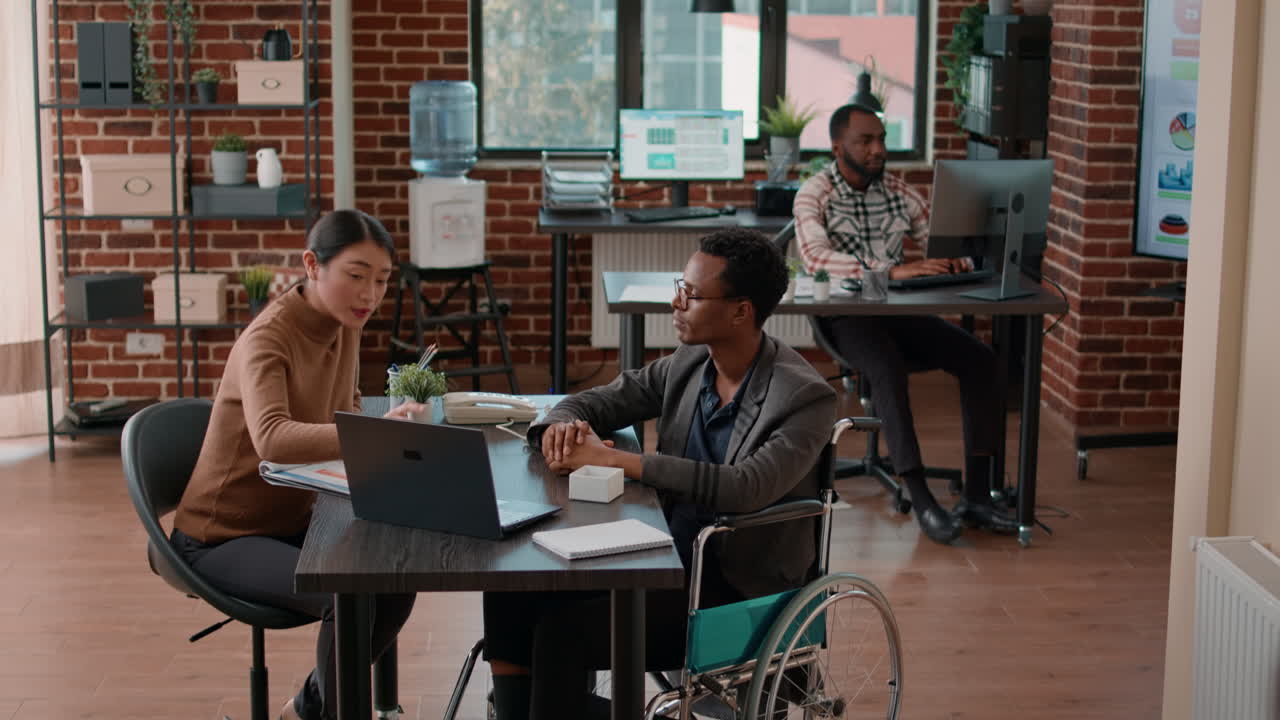 African american man with handicap talking to colleague