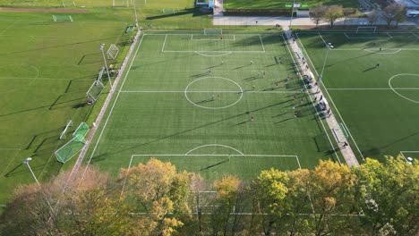 Aerial-view-of-a-soccer-match-in-autumn-in-city-park-Prinzenpark-Braunschweig,-Lower-Saxony,-Germany