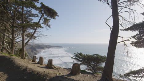 Toma-Estacionaria-Del-Acantilado-Colgando-Sobre-El-Océano-Pacífico-Con-Olas-Rompiendo-En-El-Fondo-Ubicado-En-Big-Sur-California