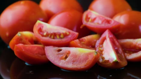 Tomates-Cherry-Enteros-Y-En-Cuartos-Sobre-Fondo-Negro-Con-Reflejo-De-Agua