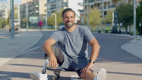 portrait of happy skateboarder with prosthetic leg on board