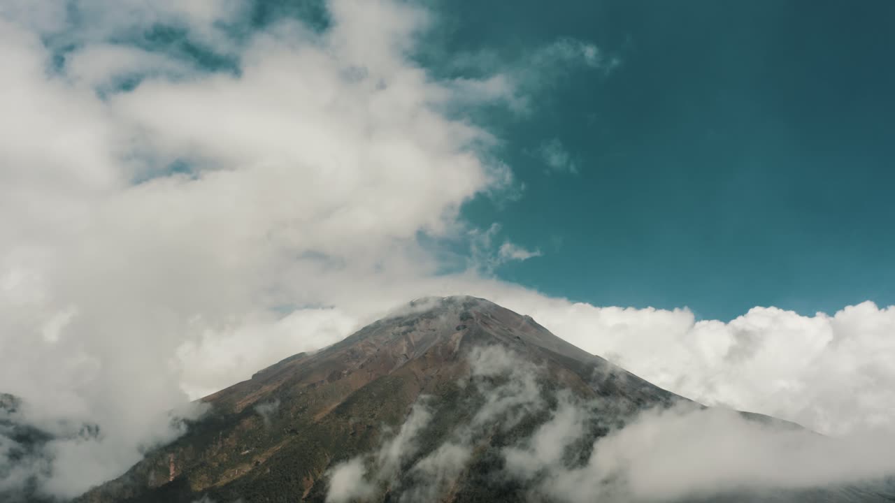 vista del estratovolcán tungurahua cubierto de nubes blancas en baños de agua santa, ecuador - amplia