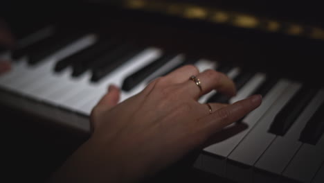 hands playing piano in the dark