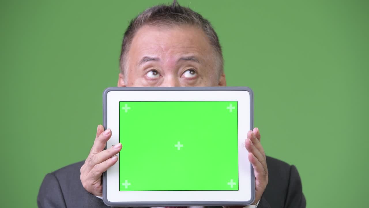 디지털 태블릿을 보여주는 성숙한 일본 사업가