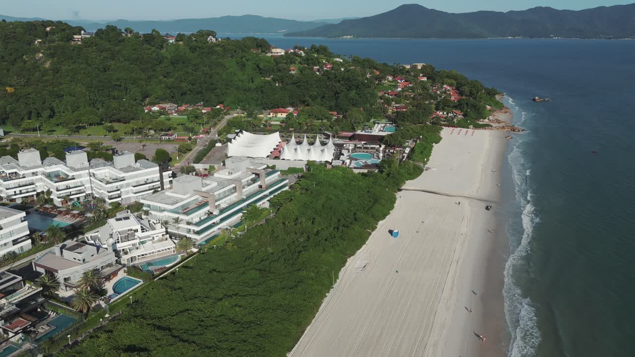 una vista aérea muestra las extensas costas de arena de la playa jurere internacional, situada en la costa norte de la isla de florianópolis, brasil.