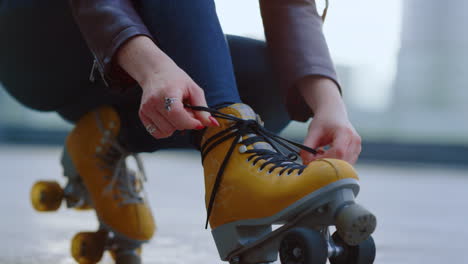 Patinador-Desconocido-Preparándose-Para-Entrenar.-Manos-De-Mujer-Atando-Cordones-En-Patines.