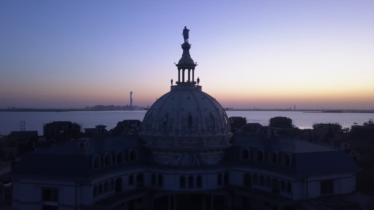 silueta de dos personas contra el cielo de la tarde en la parte superior del edificio de la cúpula