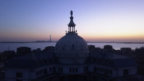 Two-people-silhouette-against-evening-sky-on-top-of-dome-building