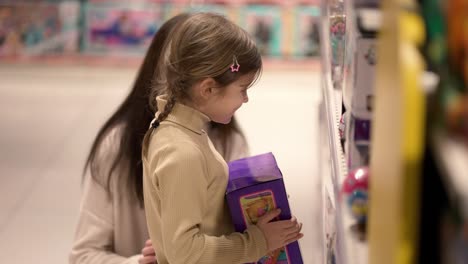 shopping concept. mother and daughter are buying dolls in the mall