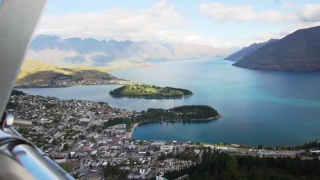 sliding reveal of queenstown, new zealand from above at the gondola