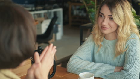 young female friends talking in a coffee shop