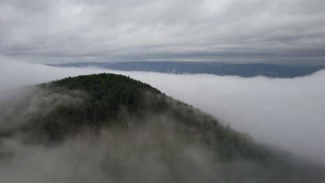 Aerial-orbit-over-the-mountain-summit-with-vapor-around