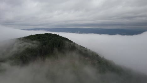 aerial orbit over the mountain summit with vapor around