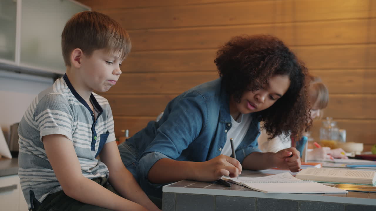 Children doing homework together in the kitchen