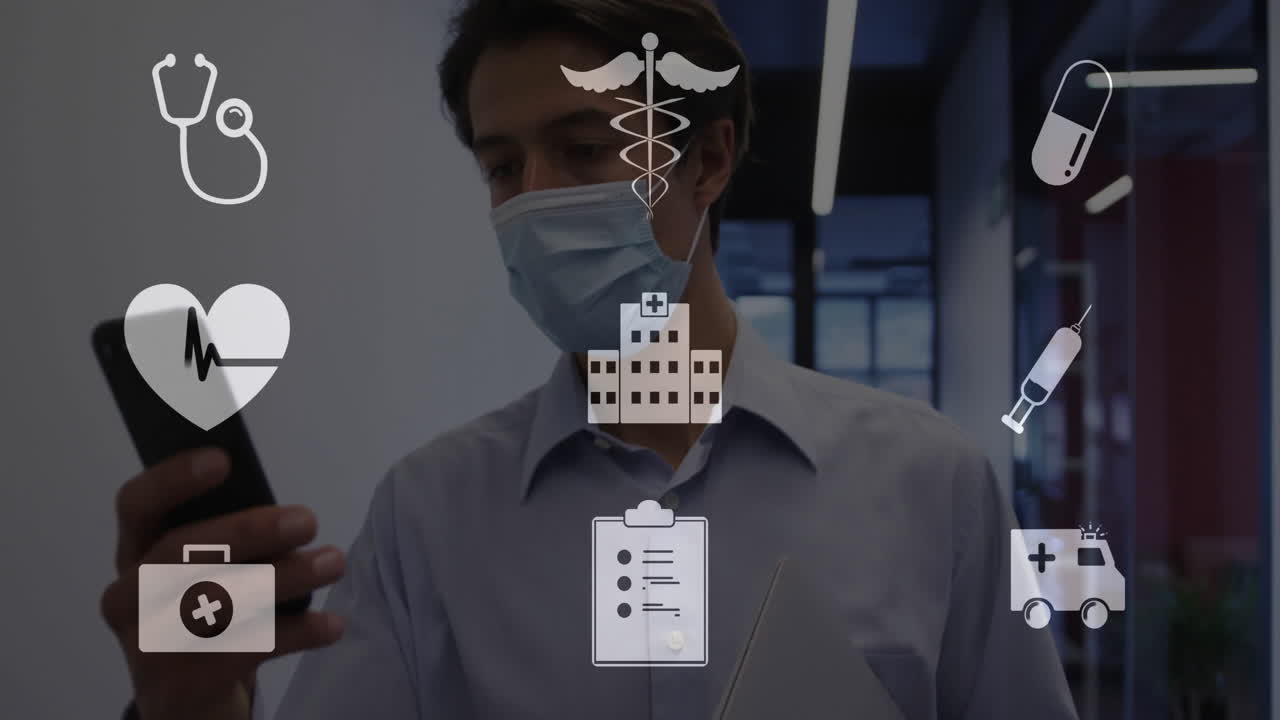 Animation of medical icons over smiling caucasian businessman in facemask using smartphone
