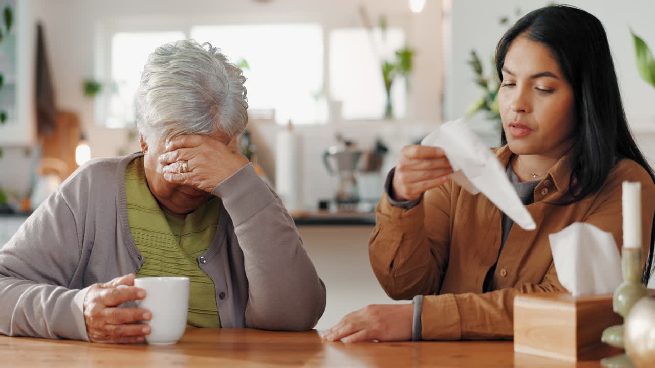 한 젊은 여성 이 부 테이블 에서 울고 있는 노인 어머니 를 위로 하고 있다
