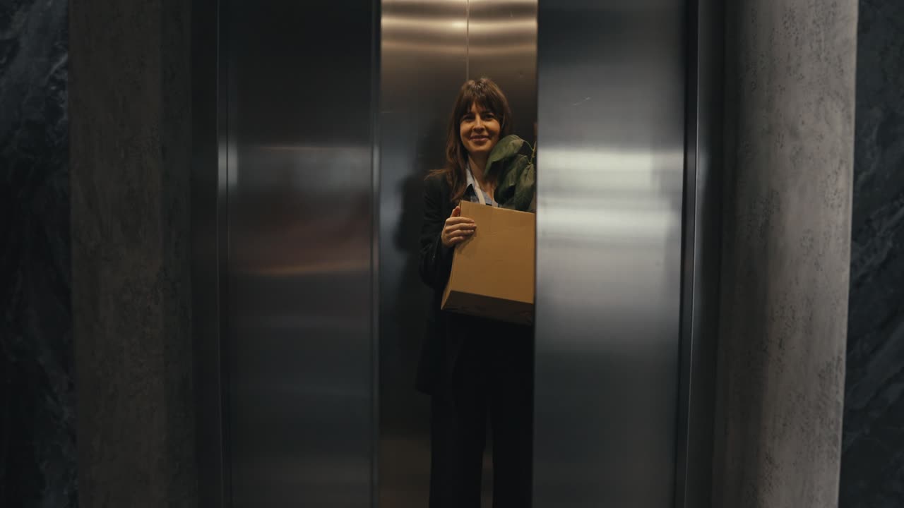 Woman Leaving Office with Box and Plant