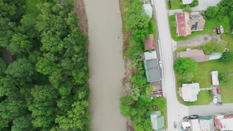 Toma-Aérea:-Río-Desbordado-Adyacente-A-Una-Zona-Residencial-En-Ludlow,-Vt,-Inundaciones-Poshistóricas