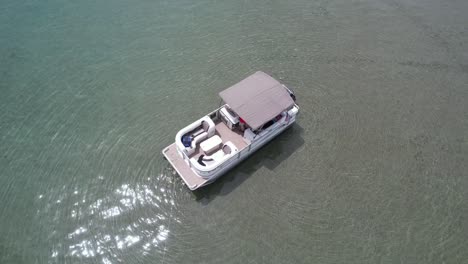 A-pontoon-boat-is-anchored-on-the-edge-of-the-drop-off-at-Detroit-Point-on-Higgins-Lake,-Roscommon,-MI-4