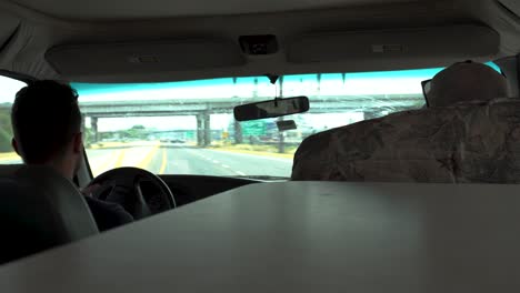 two men drive an rv through a small town.