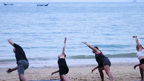 group practicing yoga by the ocean