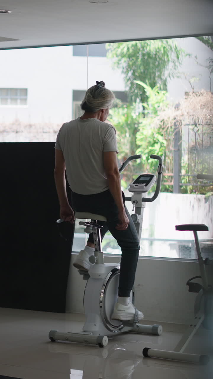 Uomo che si allena su una cyclette in una palestra moderna