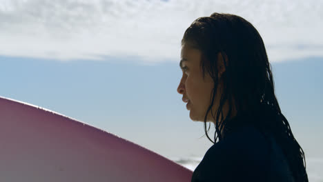 Woman-with-surfboard-standing-on-the-Beach-4k