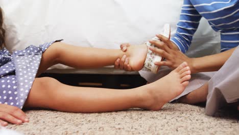 Mother-helping-her-daughter-to-wear-a-shoes-in-bedroom-4k