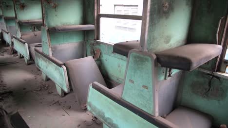 dentro de un viejo tren oxidado con muchos asientos de pasajeros rotos