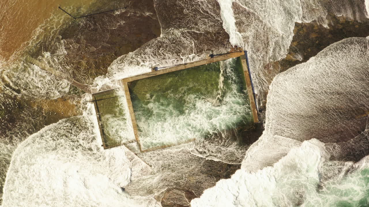 파도가 부 ⁇ 혀서 시드니의 북쪽 해변에 있는 모나  ⁇ 레 해변의 조류 수영장에 흘러들어갑니다.