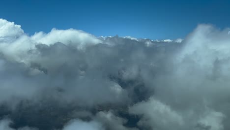 Pilot-POV-flying-across-some-fluffy-white-and-grey-clouds