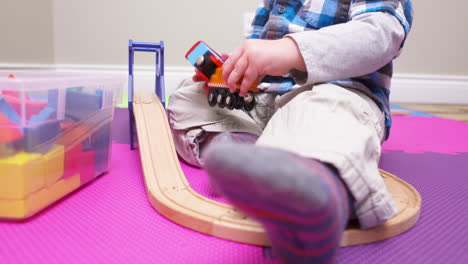 baby boy playing with a toy train set