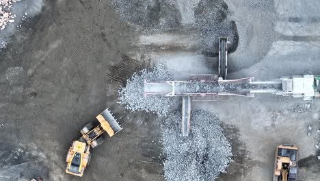 tiro de drone de cinta transportadora clasificando rocas y escombros en montones en mina de cantera