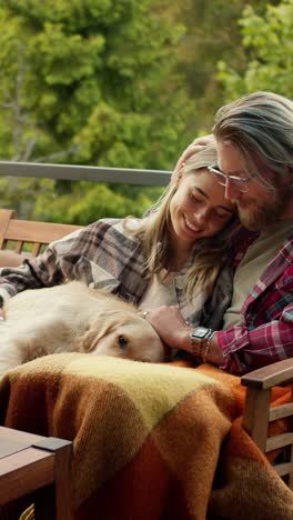couple relaxing with dog on balcony