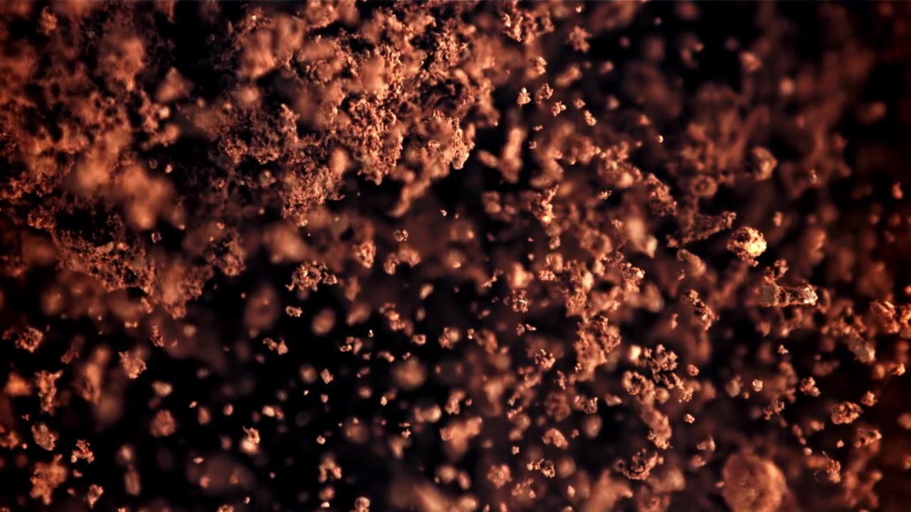 Slow Motion of Dark Brown Particles Focusing on a Black Background