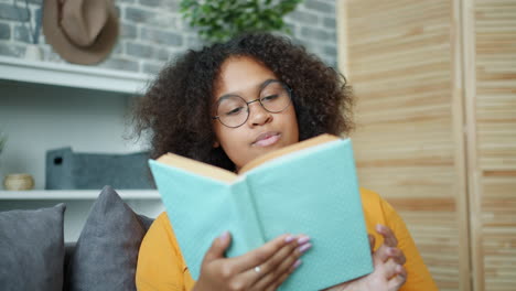 young woman reading a book on a sofa