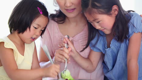 daughters helping their father toss salad