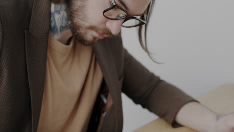 man working on laptop and writing notes