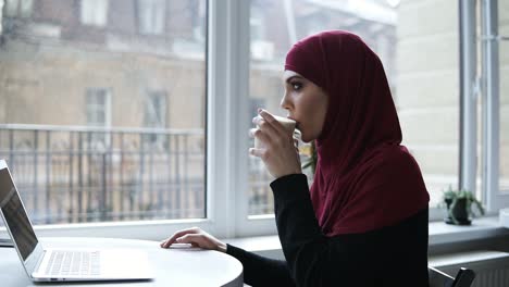 Gorgeous-arabic-girl-is-drinking-cappuccino.-Indoors-slow-motion-footage