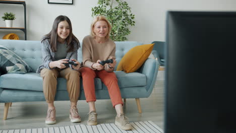 grandmother and granddaughter playing video games together