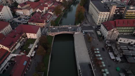 aerial-dolly-in-tit-down-shot-Saint-Peter's-Bridge-in-old-town-of-Ljubljana-city-Slovenia-in-sunset-time