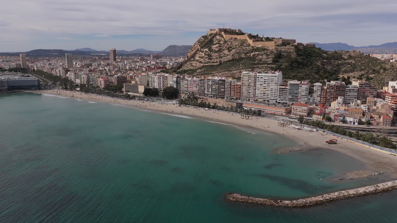 Alicante'nin Playa del Postiguet'inin Benacantil Dağı'ndaki Santa Bárbara Kalesi ile çekilmiş havadan drone görüntüleri. İspanya'daki Costa Blanca boyunca Akdeniz kıyı şeridi ve şehir silüeti.