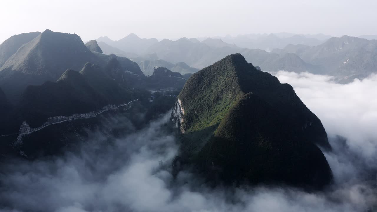 hermosas montañas kársticas asiáticas que se elevan por encima de las nubes bajas, vista aérea