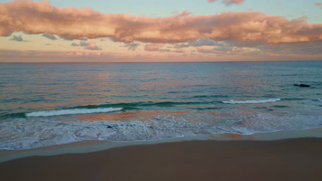 aerial coastal sunset landscape view in pink hues. twilight descend sandy beach